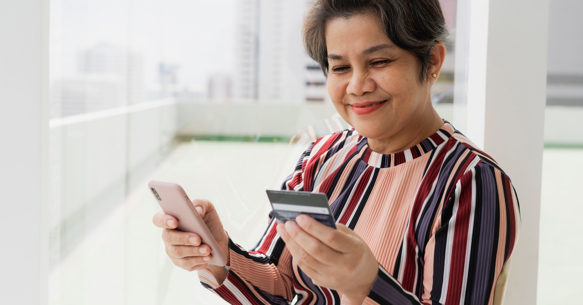 senior woman shopping with smartphone and credit card