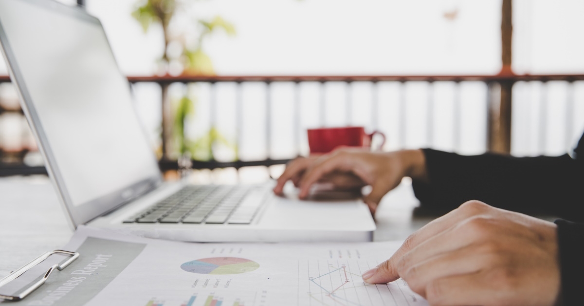 business woman sitting at table analyzing data using laptop