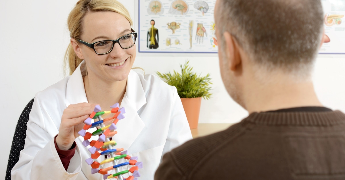 female doctor sitting in clinic with male patient explaining genetic behavior