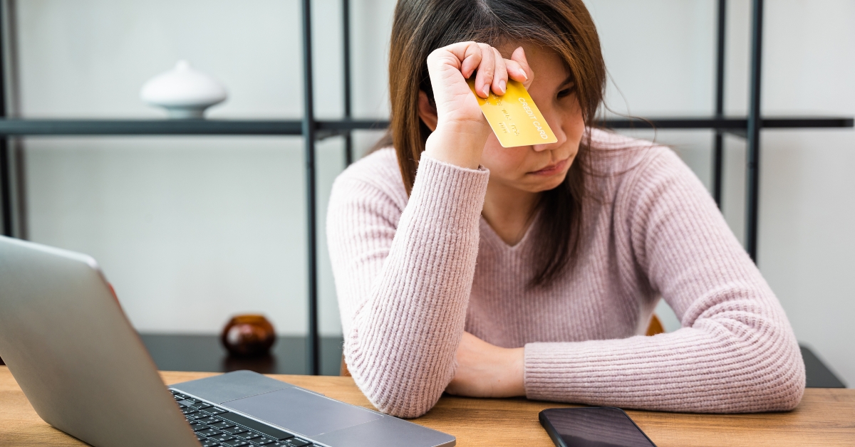 worried asian woman having problem with blocked credit card