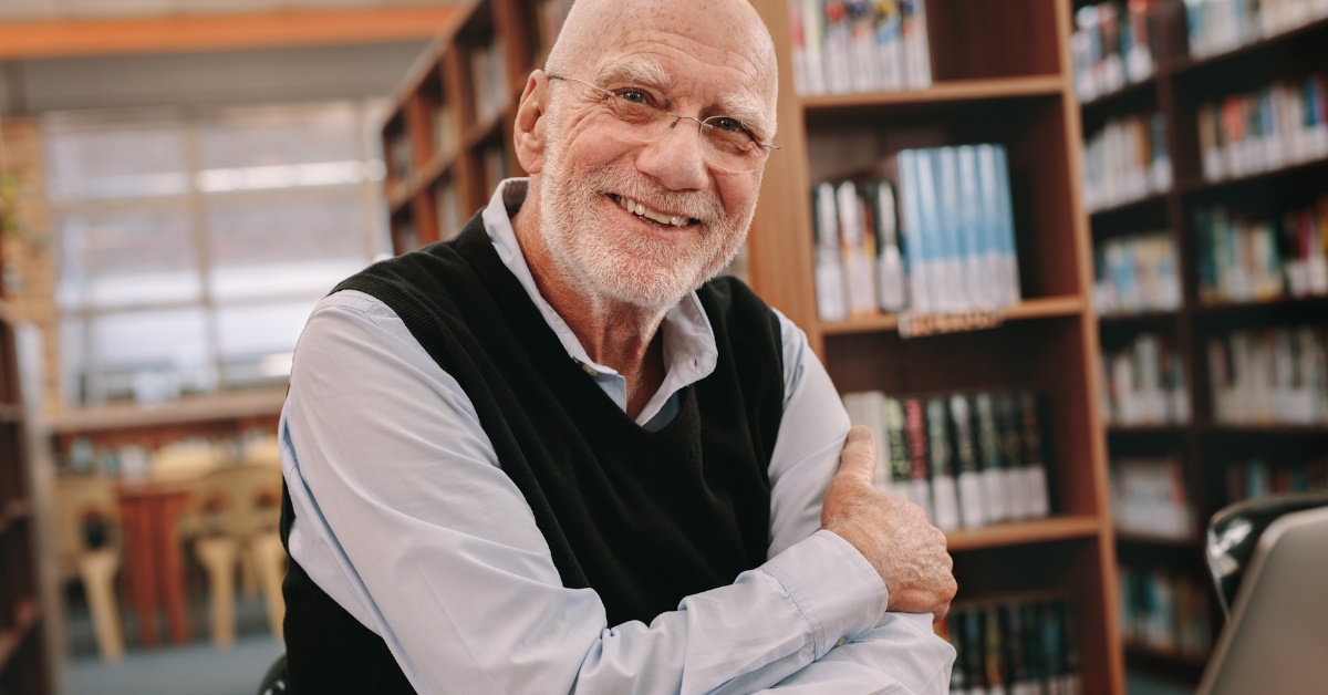 senior man smiling in library 