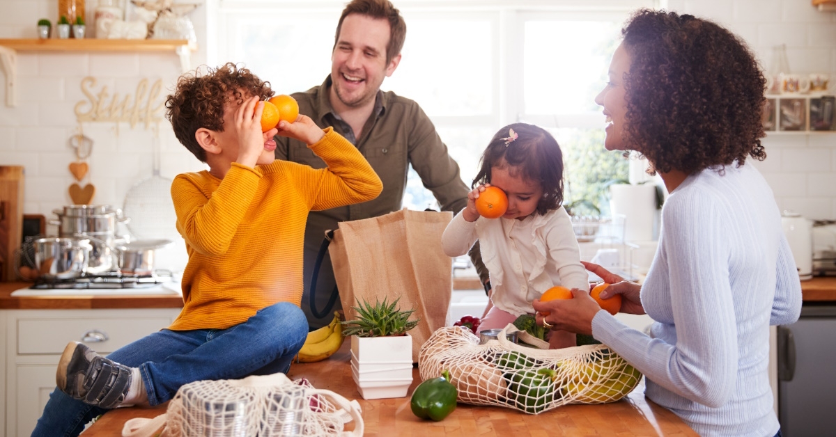 happy family having fun while unpacking grocery in kitchen home