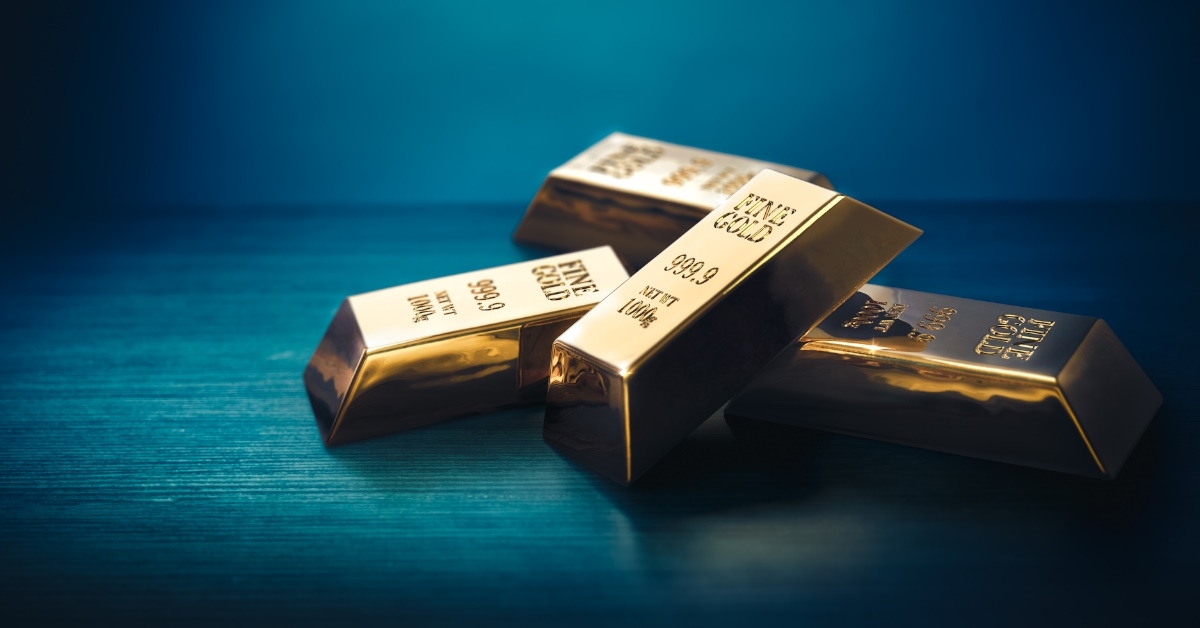pile of gold bars stacked over each other on dark backdrop