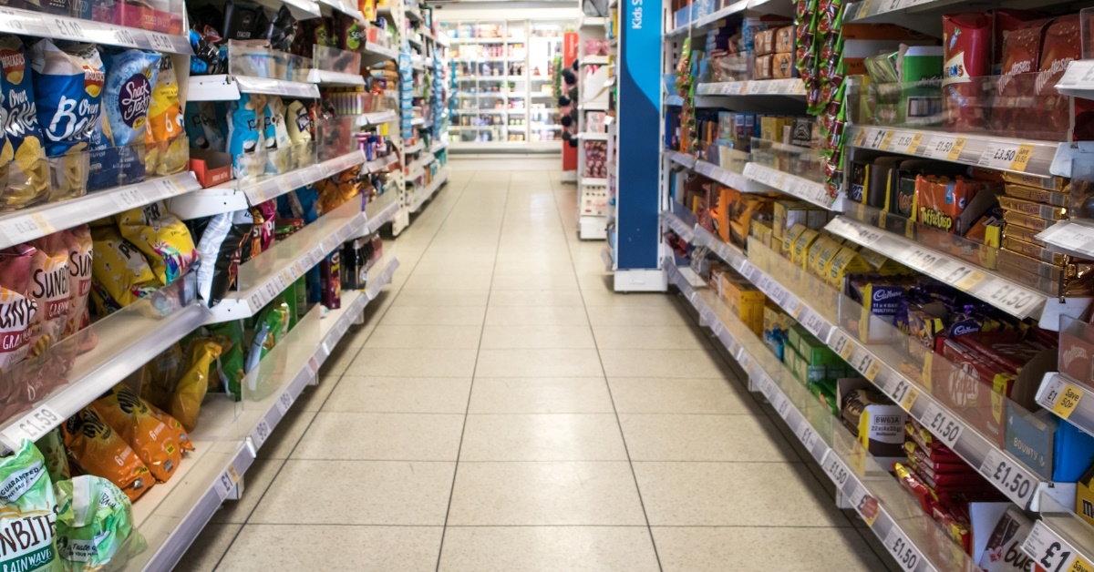 snack aisle with chips and crackers inside vacant grocery store 