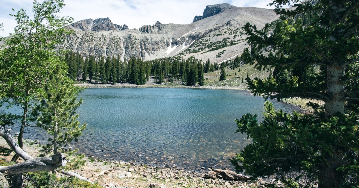 A view of Alpine lake surrounded by massive mountains and trees in Great Basin National Park, Nevada