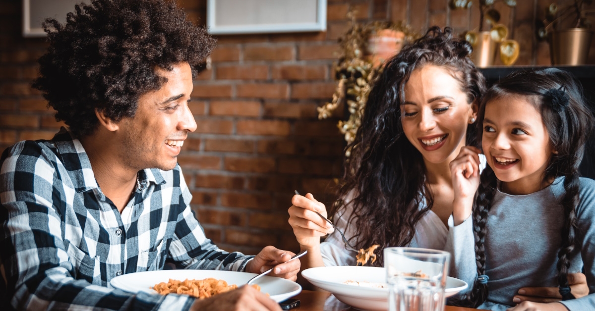 happy african american family sitting at table having lunch together