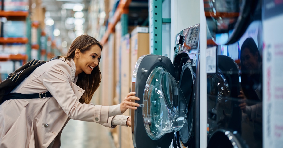 happy young woman checking front load automatic washing machines 