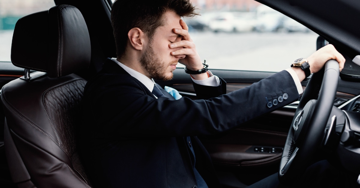 Sad businessman driving alone in his new car and missing his family.