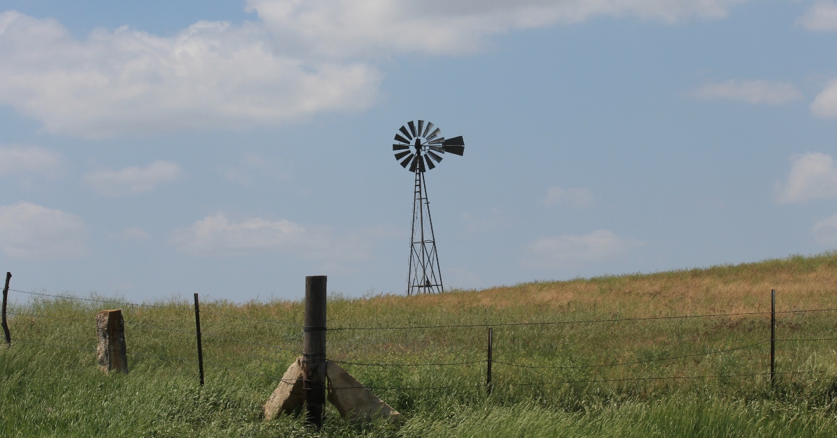 windmill in a pasture with a fence