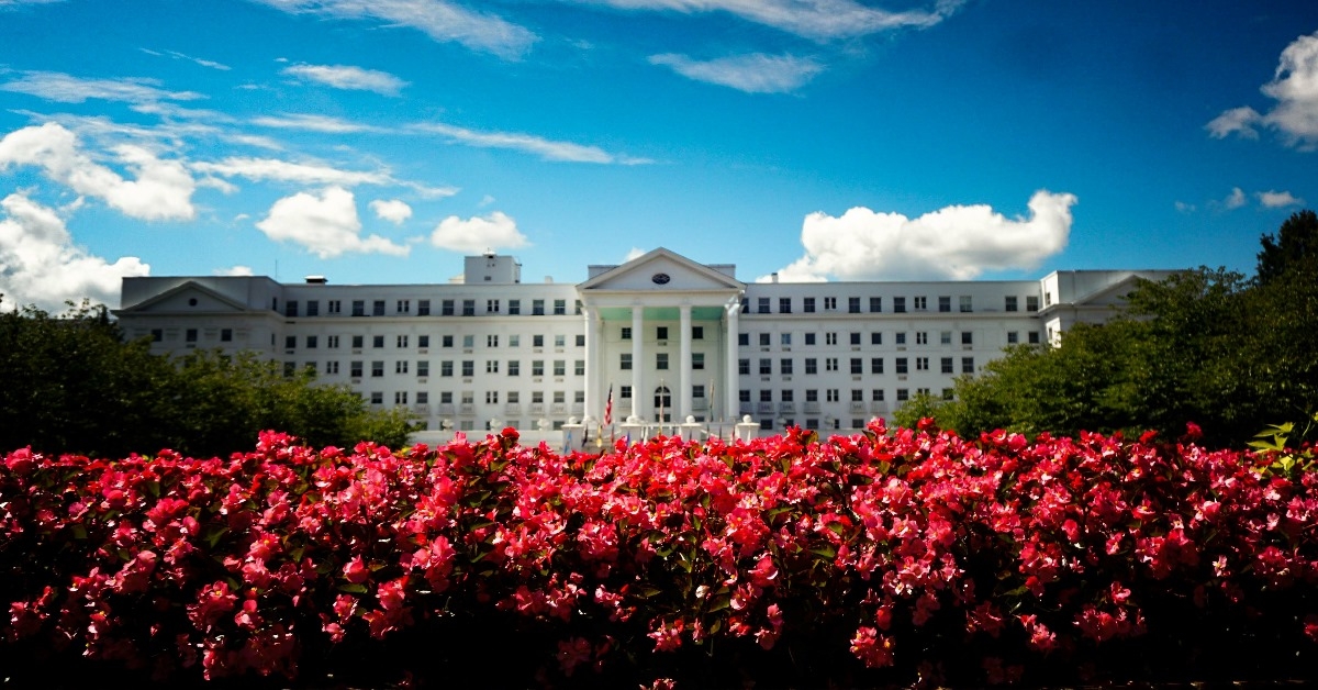 the greenbrier with beautiful landscape having pink and red color flowers under cloudy sky during day time