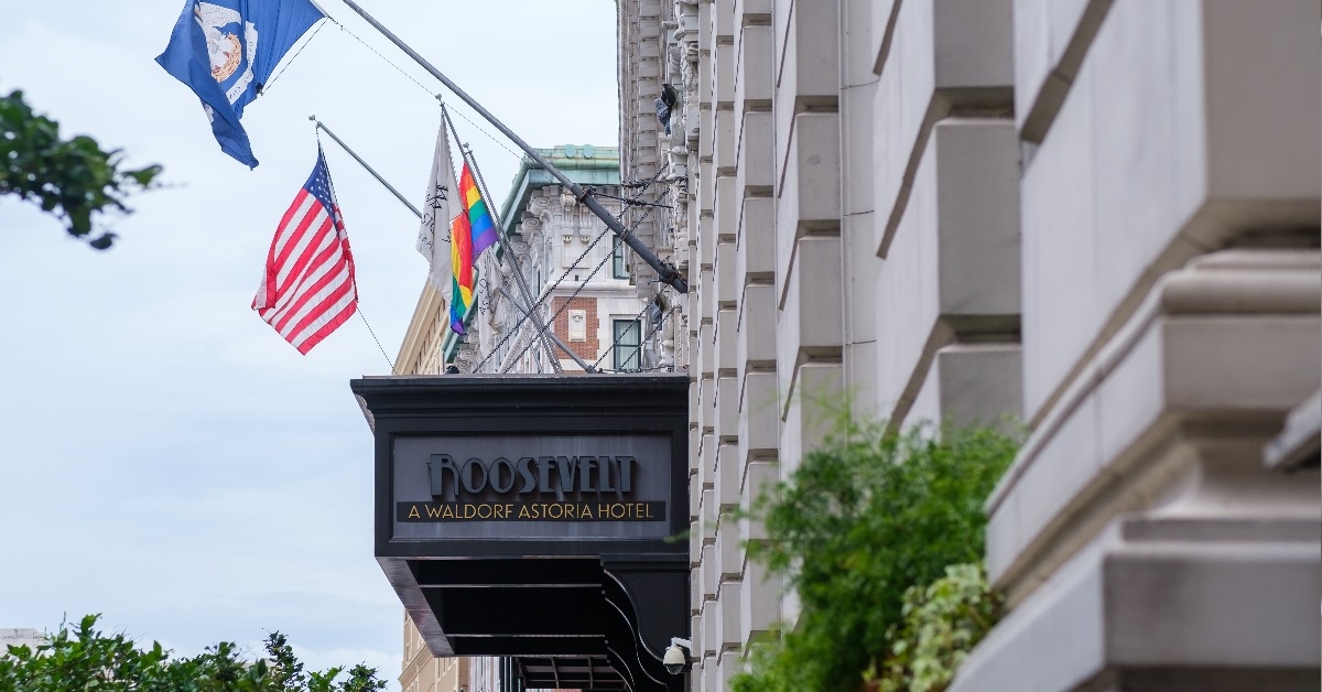 front of roosevelt hotel with flags in downtown new orleans during day time