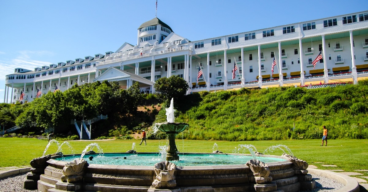 historic grand hotel with beautiful fountains and green landscape at entrance on mackinac island michigan