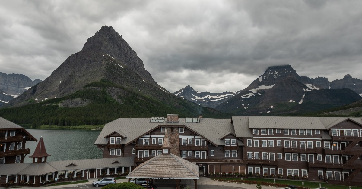 many glacier hotel and grinnell point with huge mountains and lake in background
