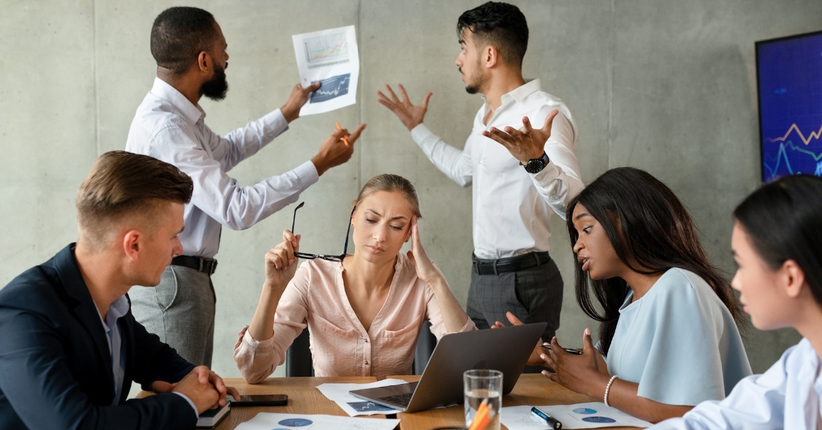 employees from diverse backgrounds in a boardroom experiencing conflict.