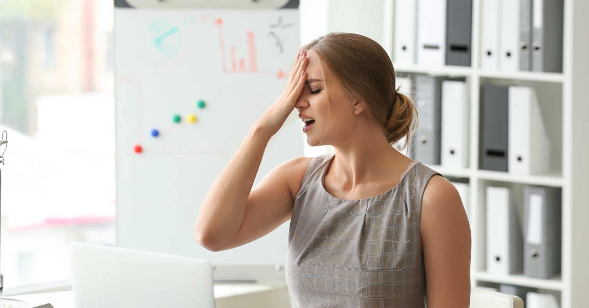 woman holding head after committing mistake at work