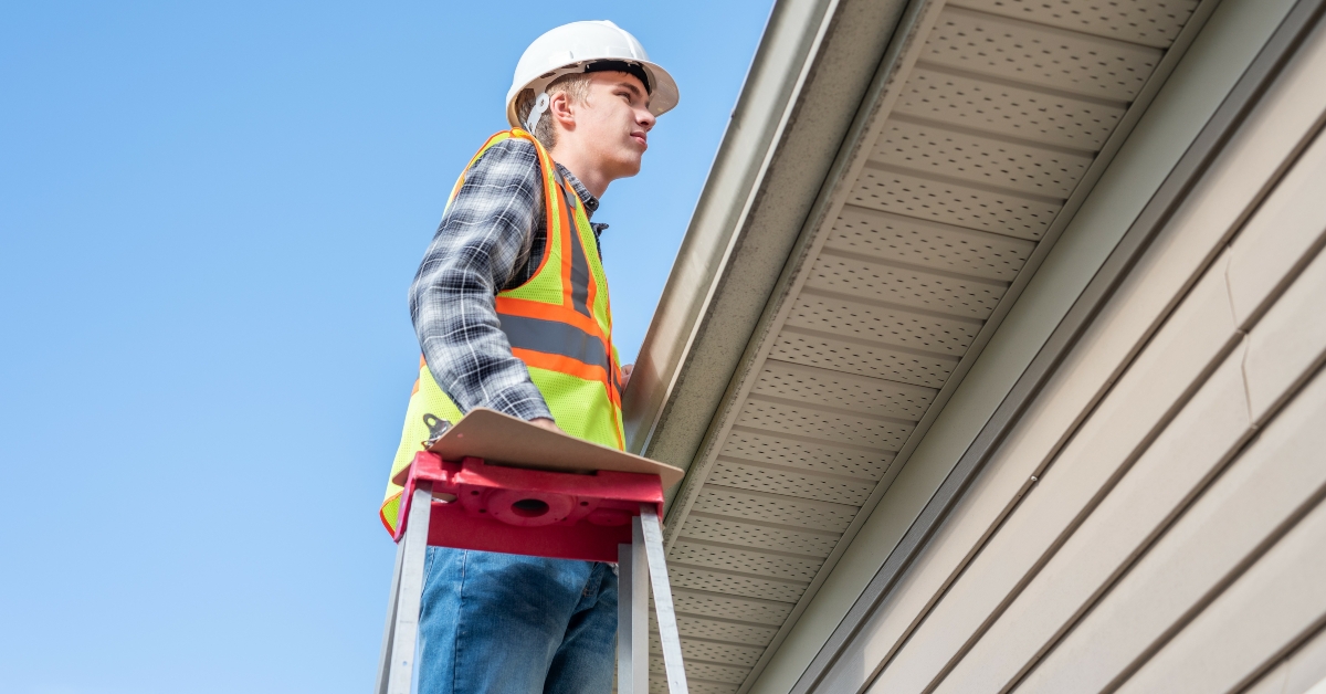 home inspector standing on a ladder