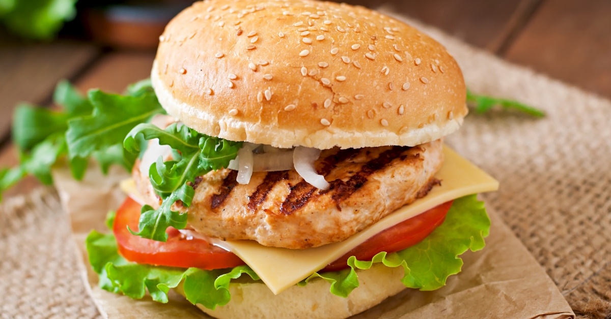 Burger with grilled chicken, tomatoes, cheese and lettuce