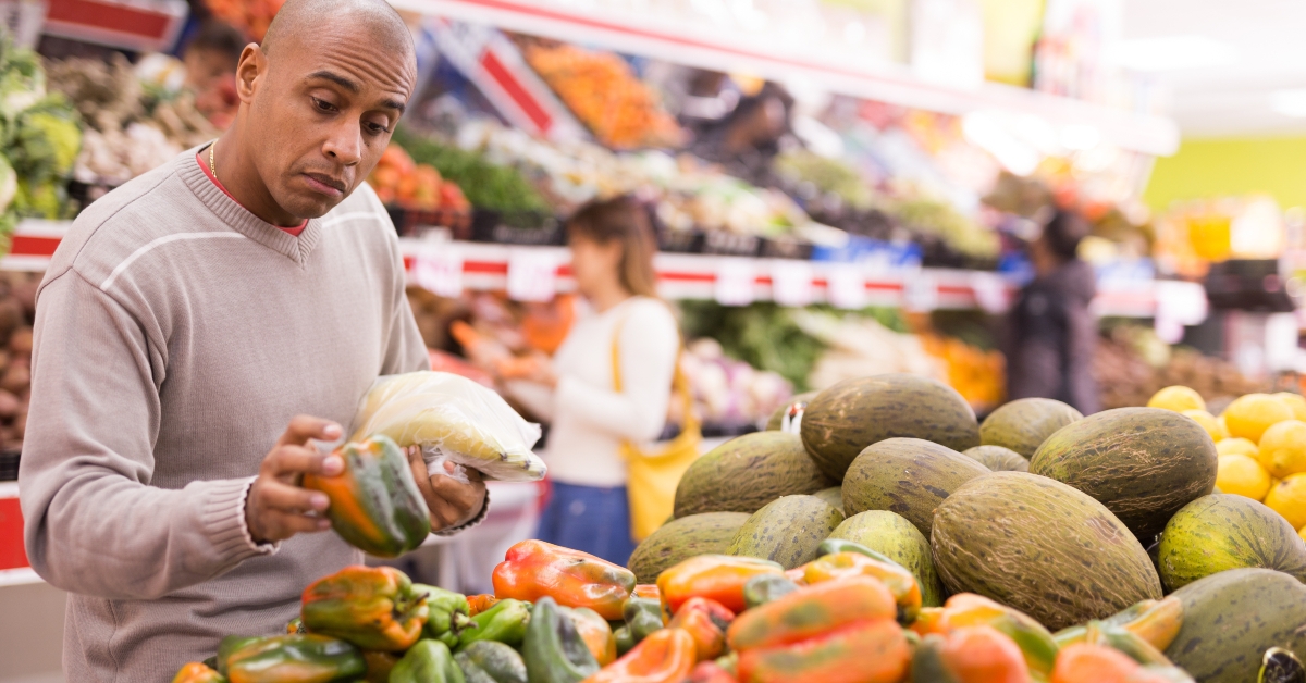 buyer selects ripe bell peppers in the vegetable section