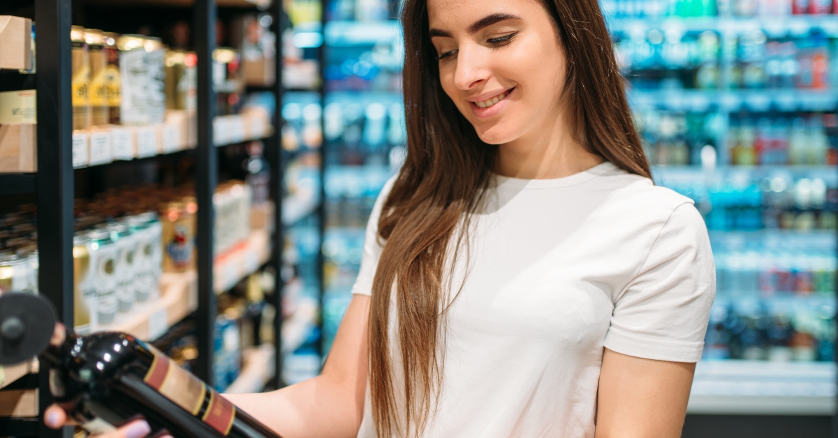 woman choosing wine in alcohol section in market