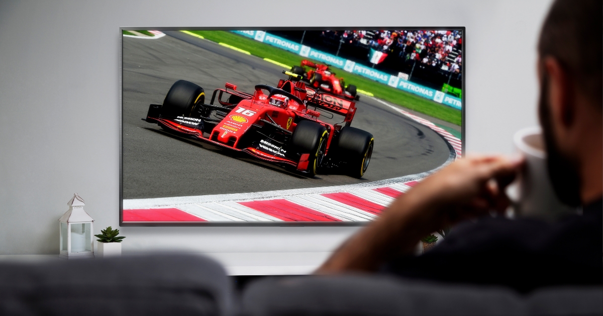 man watching formula racing on smart tv