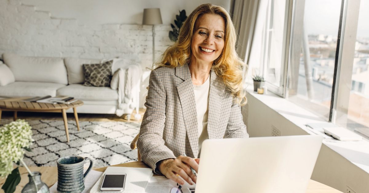 lady of 50s in plaid blazer having online meeting