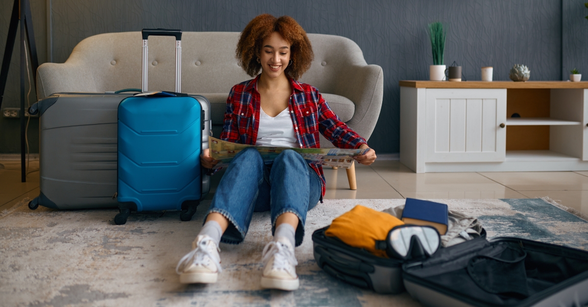 woman reading travel map surrounded with luggage