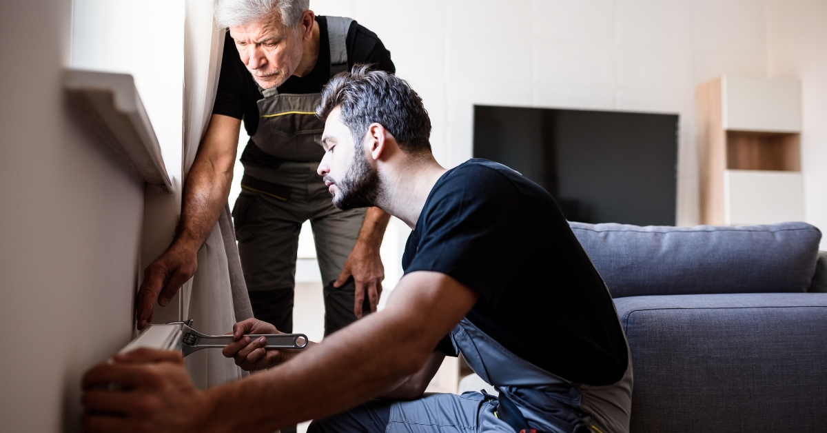workers installing heating radiator