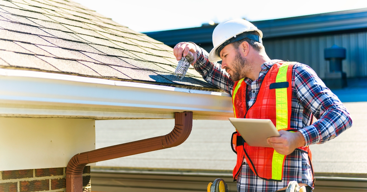 man inspecting house roof