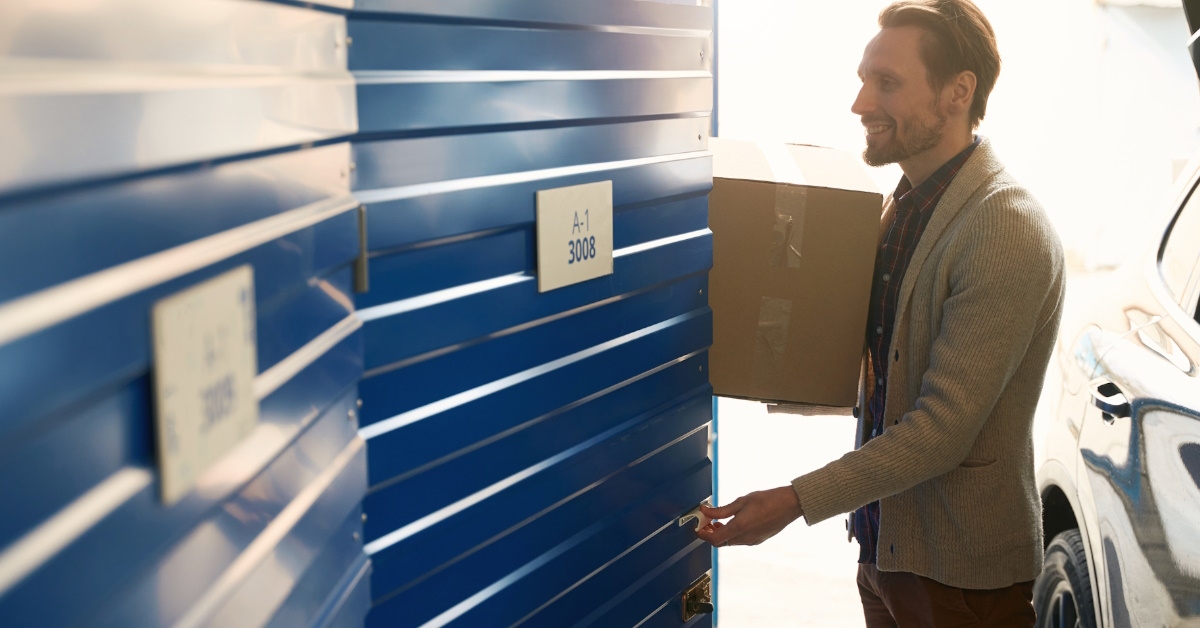 man in storage unit holding box