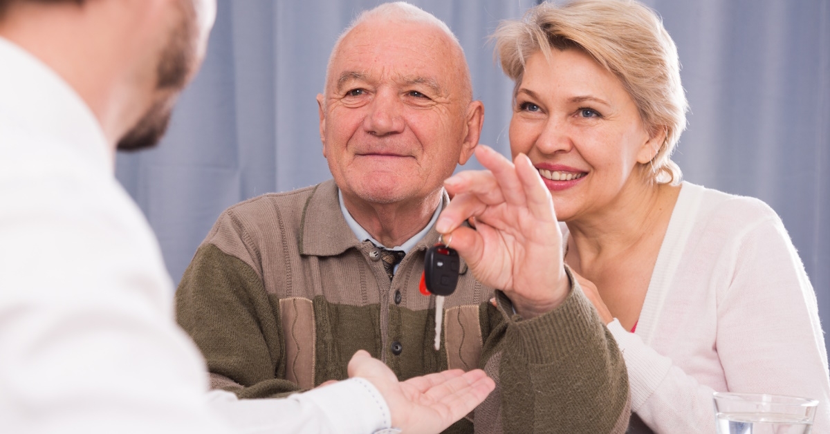 senior couple selling car holding keys