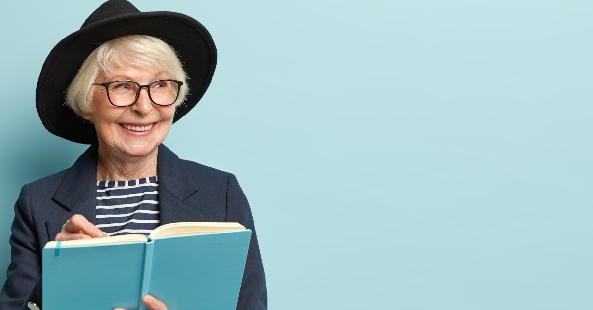 senior woman writing on book