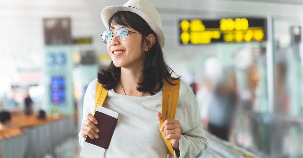 happy asian woman walking in airport
