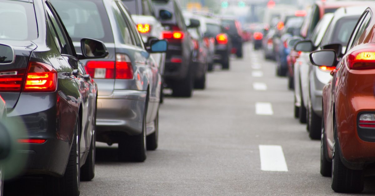 Two lines of cars stopped in traffic, seen from eye level. 