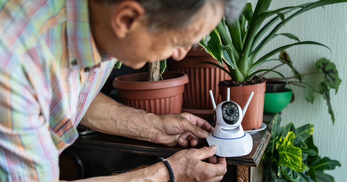 senior man holding surveillance camera