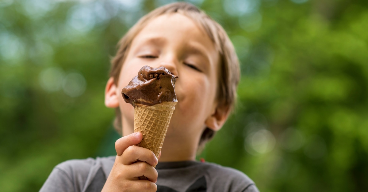 boy eating chocolate ice cream outdoors
