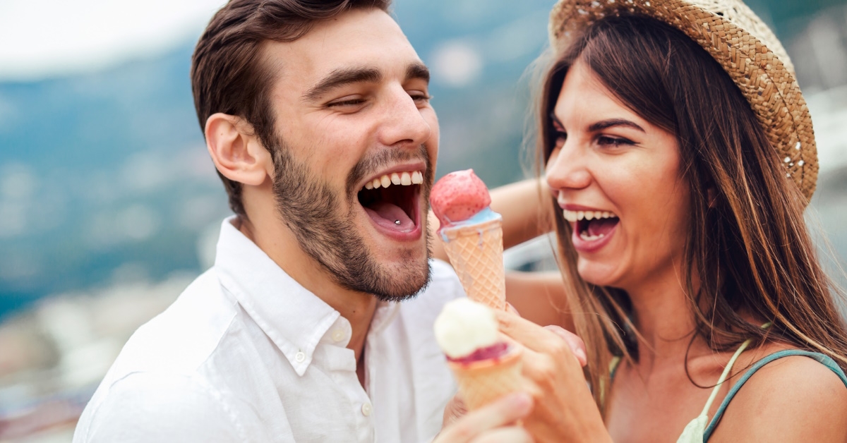 couple sharing multiflavoured ice cream outdoors.