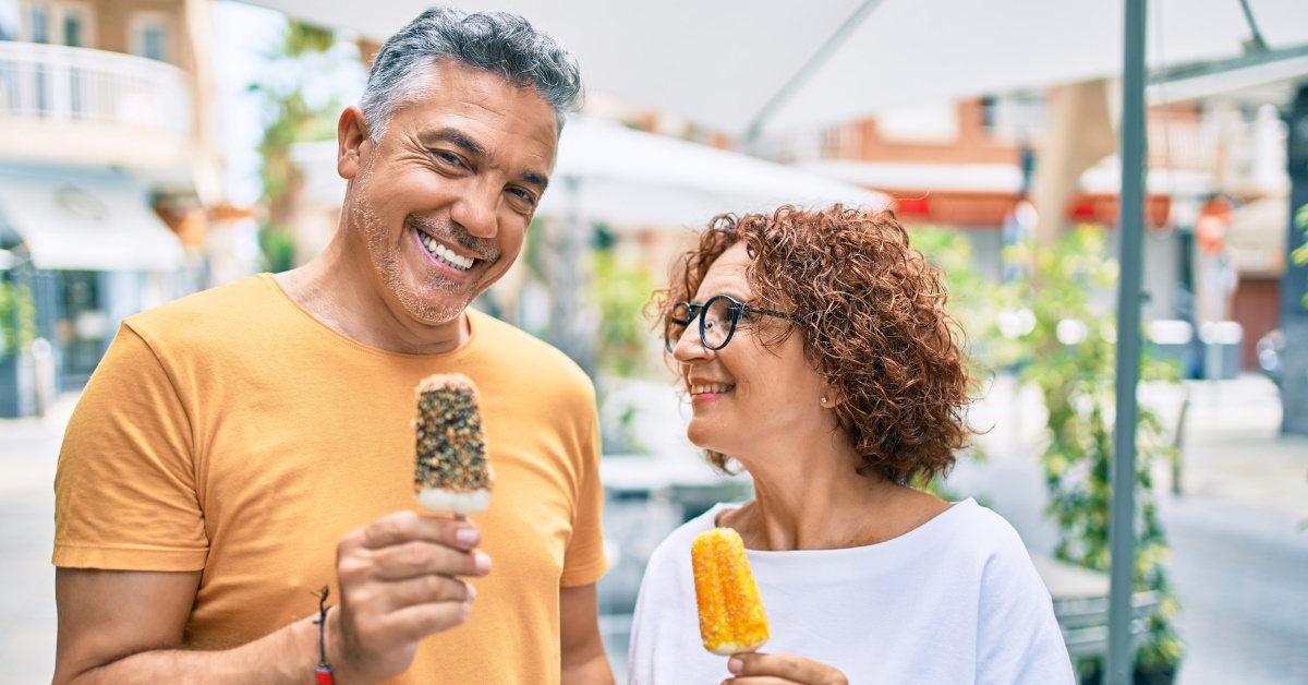 couple holding stick ice creams.
