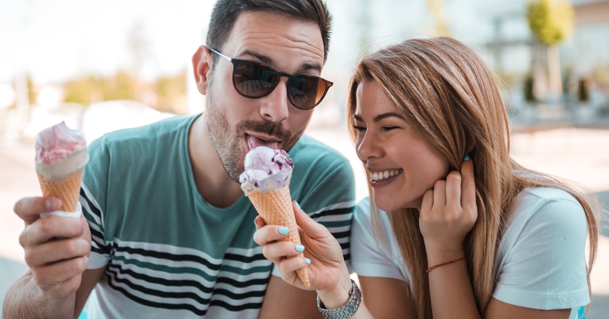 couple enjoying weather and sharing ice creams.