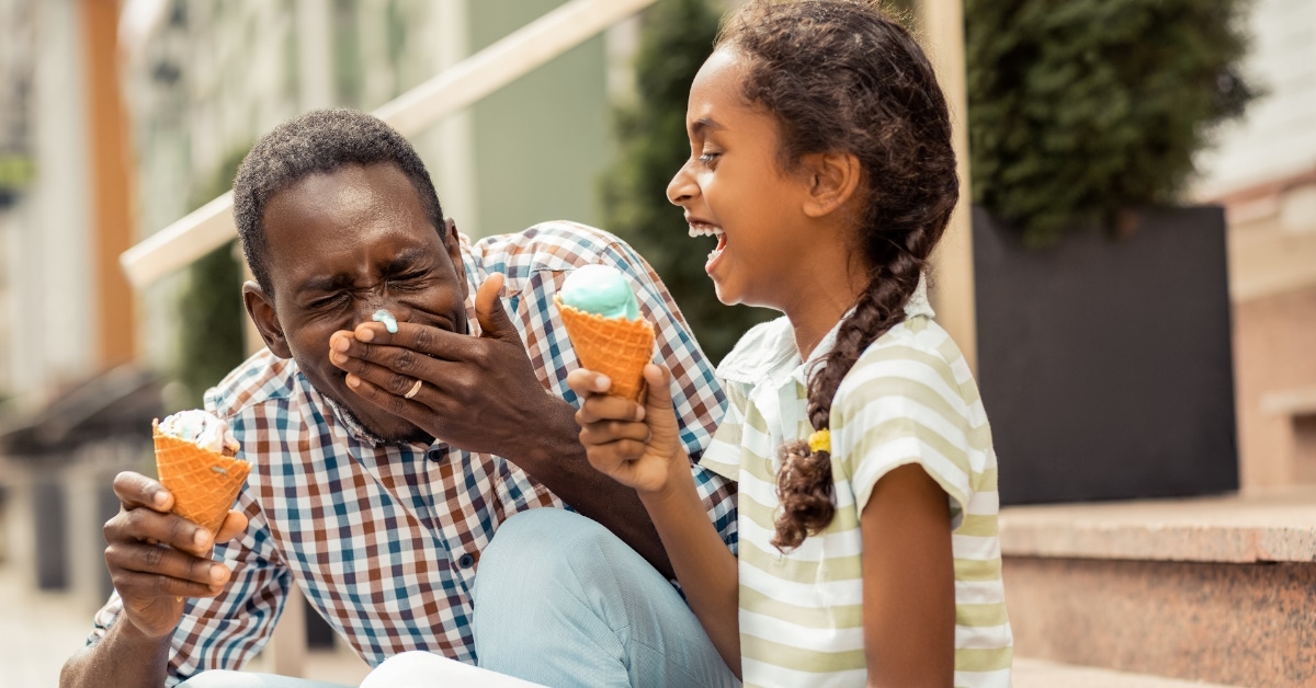 man eating icecream with his daughter.