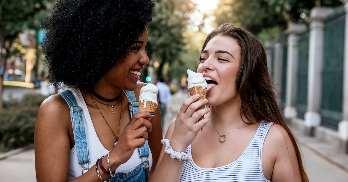 female friends eating ice cream in street.