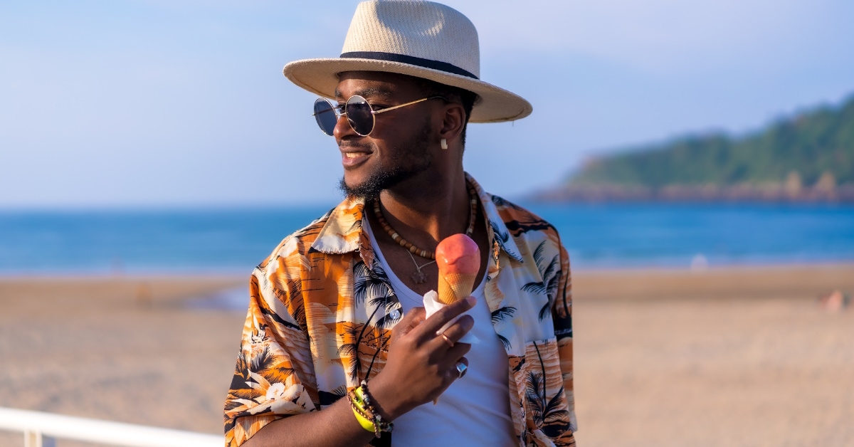 man eating ice cream at beach.