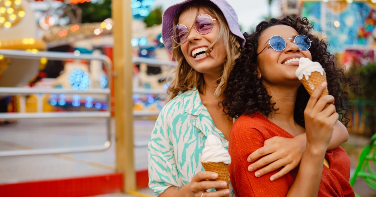 women eating ice cream in amusement park.