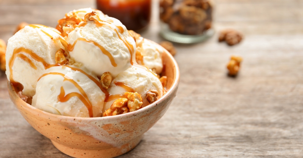 ice cream with nuts and caramel sauce in bowl.