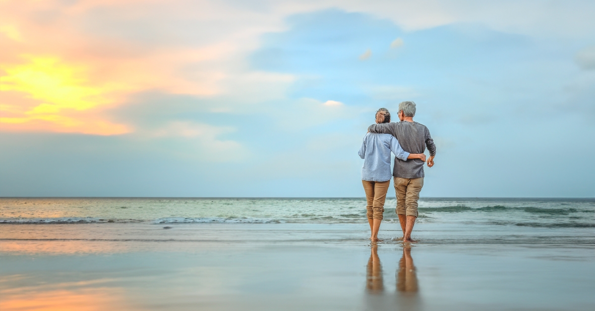 senior couple walking on the beach