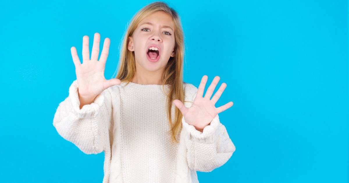 young girl in sweater saying no 