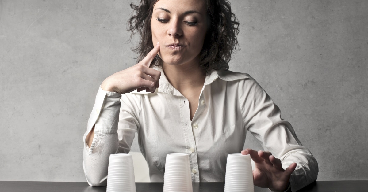woman learning conjuring tricks at table