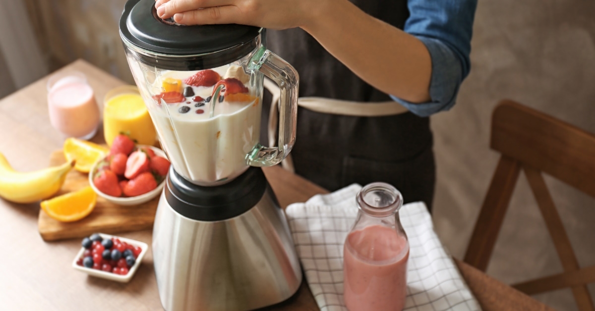 woman preparing yogurt smoothie in kitchen