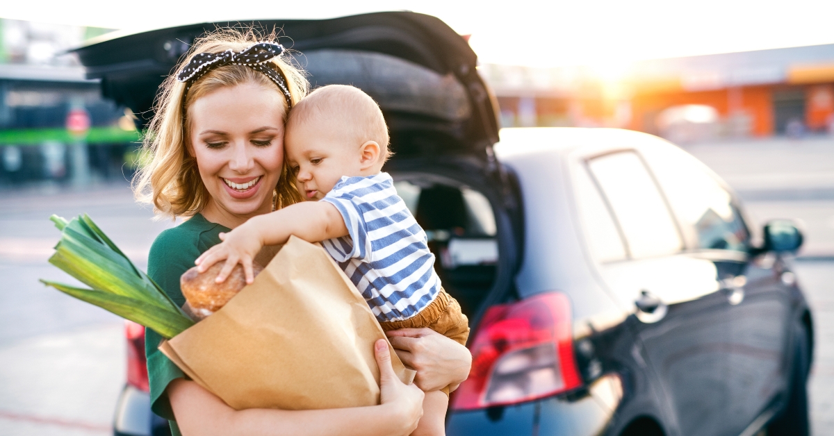 Mother carrying baby and groceries