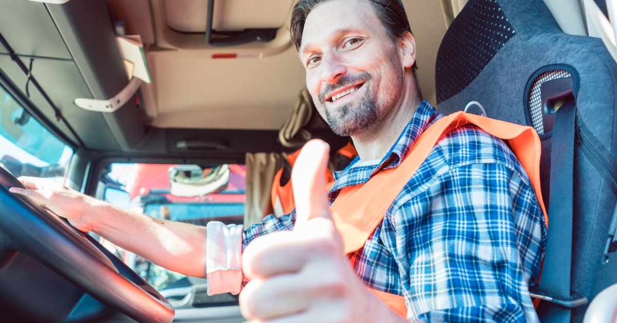 man giving thumbs up sign while driving truck.