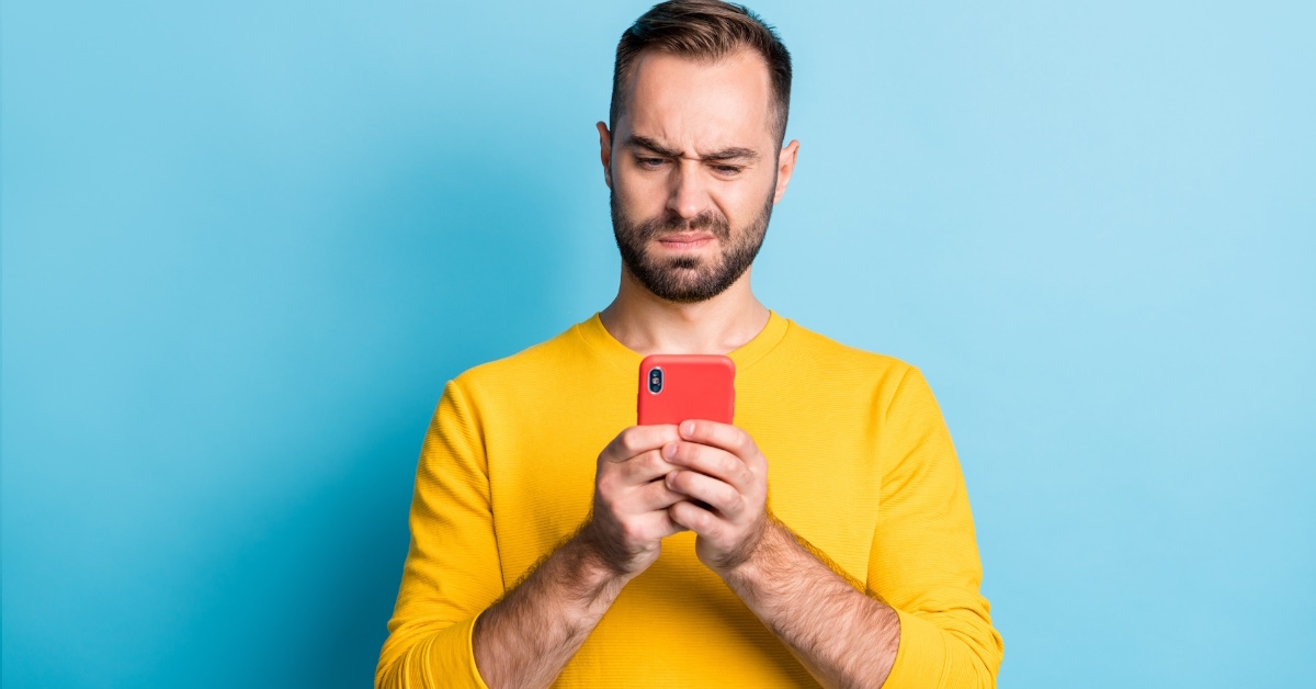 Man annoyed looking at phone